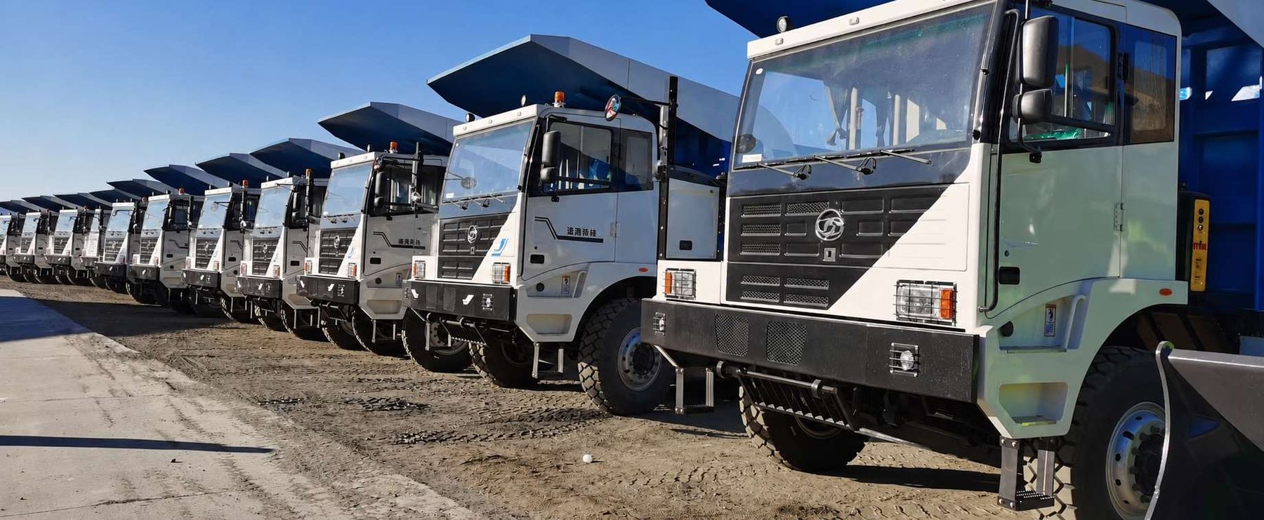 Fila de camiones tolva eléctricos listos para entrega